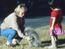 Woman holding a porcupine in front of little girl